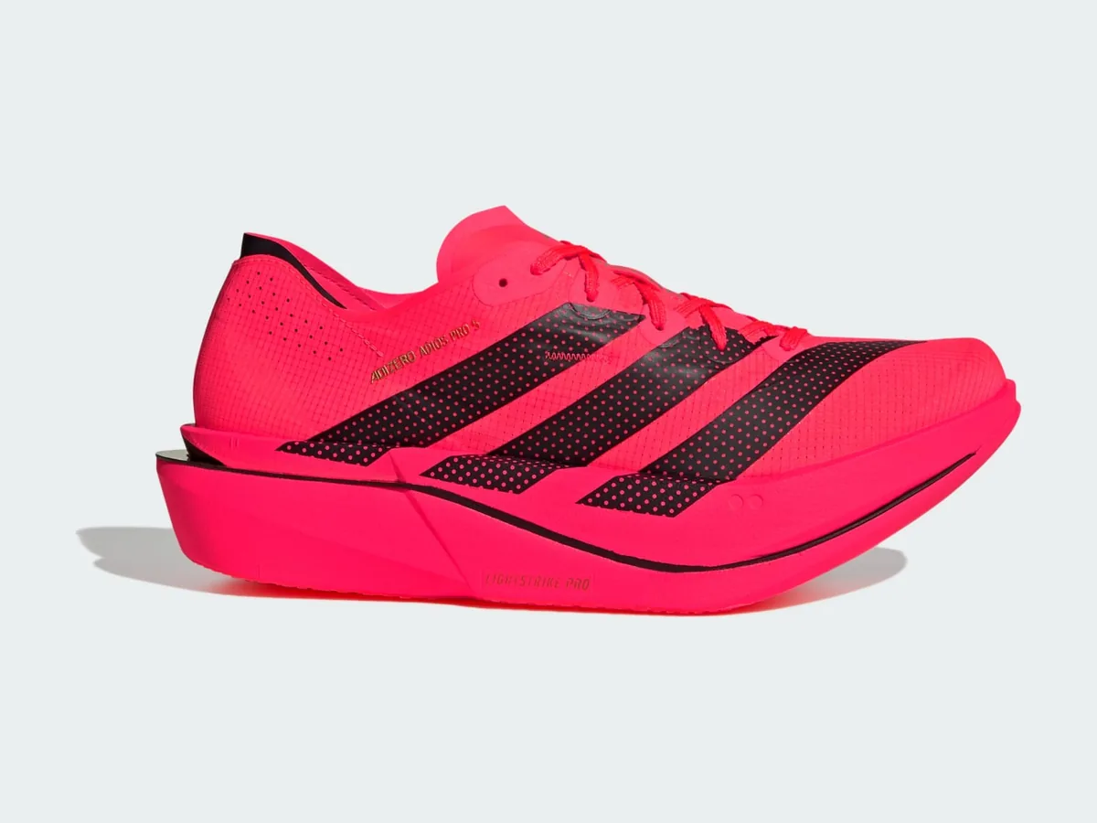 adidas Adizero Adios Pro 5 racing shoe in pink with black stripes, side view