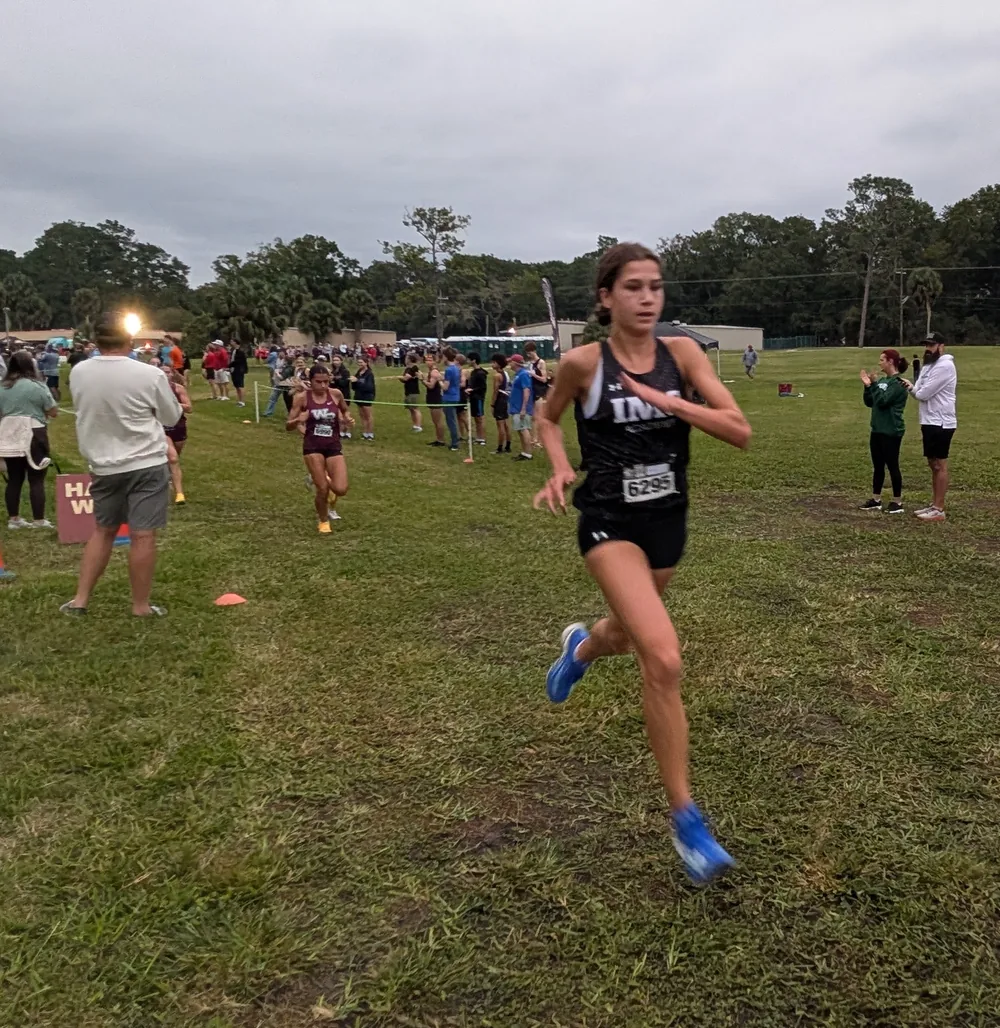 Emma Balaban of IMG Academy, bib 6295, leading the girls' Elite race, with Natalia Gaona-Zelaya of Wiregrass Ranch, bib 6990, behind her