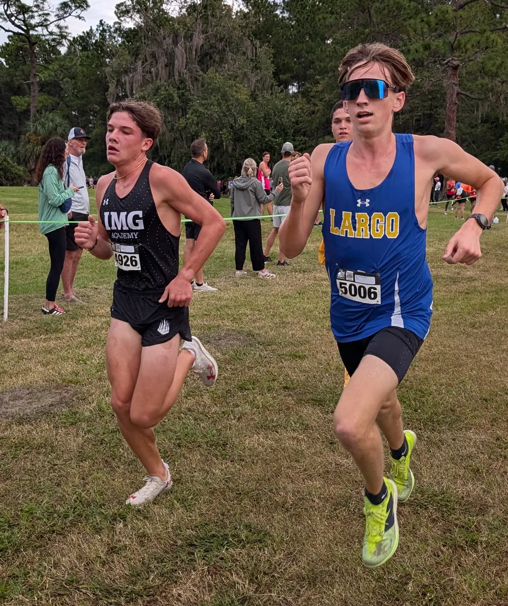 Isaiah Howdeshell of Largo, bib 5006, in a blue singlet, running beside Fletcher Rodbro of IMG Academy, bib 4926